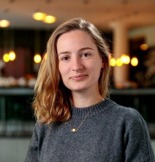 Portrait von Sarah Tegeler in einem grauen Pullover und mit einer goldenen Kette